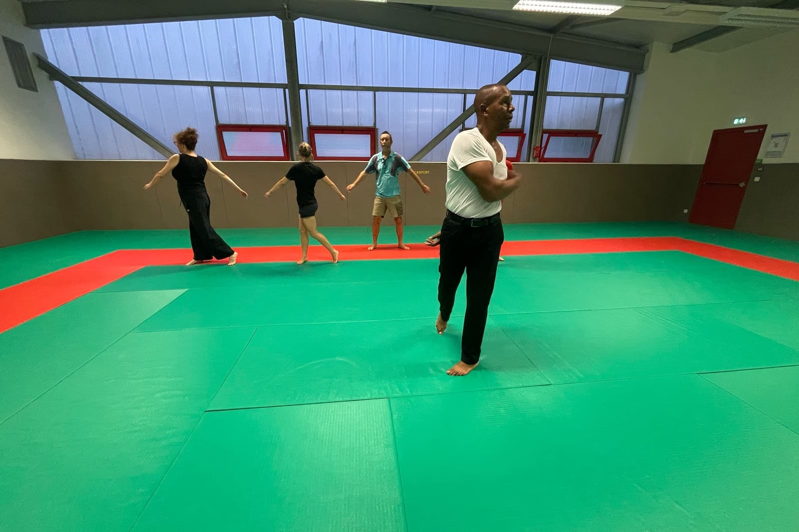 Exercice de mobilité debout pendant le cours seniors du Kobukaï, sur le tatami du complexe sportif Le Derf à Séné