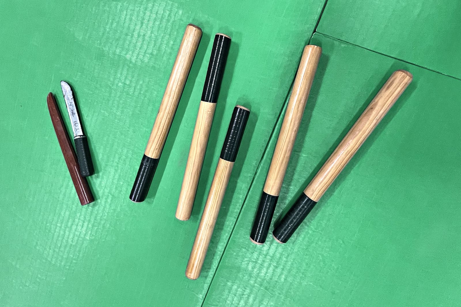 Bâtons et couteaux d’entraînement posés sur le tatami du Kobukaï, à Séné